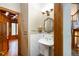 Charming powder room with pedestal sink, decorative mirror, and is adjacent to the handsome office at 3935 Pierson St, Wheat Ridge, CO 80033