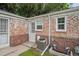 Brick house rear exterior with an air conditioner, small patio and metal screen doors at 1279 Leyden St, Denver, CO 80220