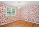 Stylish bedroom with bright floral wallpaper, gleaming wood floors, and a chandelier at 1279 Leyden St, Denver, CO 80220