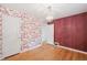 Bedroom featuring wood floors, charming wallpaper and access to another room at 1279 Leyden St, Denver, CO 80220