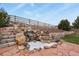 Backyard landscaping with water feature cascading down stonework at 1457 Rosedale St, Castle Rock, CO 80104