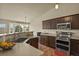 Well-lit kitchen featuring stainless steel appliances, wooden cabinets, and a view to the outside at 1457 Rosedale St, Castle Rock, CO 80104