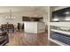 Open-concept living room and kitchen with hardwood floors and modern lighting fixtures at 1457 Rosedale St, Castle Rock, CO 80104