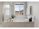 Elegant bathroom featuring a soaking tub, shower, and large windows at 515 Orion Ave, Erie, CO 80516