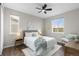 Bright bedroom with a queen-sized bed, ceiling fan, and sunlit windows at 515 Orion Ave, Erie, CO 80516