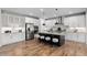 Bright kitchen boasts white cabinetry, stainless appliances, granite counters, and a large island with bar stool seating at 515 Orion Ave, Erie, CO 80516