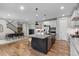 Contemporary kitchen showcases an island with granite countertop, seating, and stainless appliances open to dining and living space at 515 Orion Ave, Erie, CO 80516