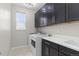 Well-equipped laundry room with modern washer, dryer, and ample counter space at 515 Orion Ave, Erie, CO 80516