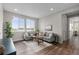 Cozy living room with large windows, comfortable seating, and hardwood floors at 515 Orion Ave, Erie, CO 80516