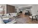 Open-concept living room featuring modern decor, wood floors, and seamless flow to the kitchen at 515 Orion Ave, Erie, CO 80516