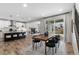 Open-concept living space with island kitchen, modern dining and fireplace, and access to the outdoor living area at 515 Orion Ave, Erie, CO 80516