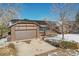 Brick ranch house with attached garage and snow-covered yard at 10665 W 79Th Pl, Arvada, CO 80005