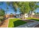 The backyard features a large tree, artificial turf and a pathway to the back of the property at 1060 Grove St, Denver, CO 80204