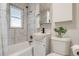 Clean bathroom features a shower-tub combo, marble tile, and white fixtures at 1060 Grove St, Denver, CO 80204