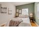 Bright bedroom with art prints, two windows, and wood floors at 1060 Grove St, Denver, CO 80204