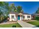 Charming single-story home with a well-manicured lawn, landscaped garden beds, and inviting blue front door at 1060 Grove St, Denver, CO 80204