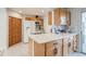 Updated kitchen features stainless steel sink, white appliances, stone counters and wooden cabinets at 1060 Grove St, Denver, CO 80204