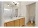 Bathroom featuring a double vanity, large mirror, modern fixtures, and a toilet closet at 19691 E 59Th Dr, Aurora, CO 80019