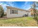Rear exterior view showcasing a well-maintained home, lawn, patio, and outdoor grill area at 19691 E 59Th Dr, Aurora, CO 80019