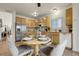 A full kitchen boasts wood cabinets, stainless steel appliances and a dining table for four at 19691 E 59Th Dr, Aurora, CO 80019