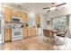 A full kitchen boasts wood cabinets, stainless steel appliances and a ceiling fan above a dining table for four at 19691 E 59Th Dr, Aurora, CO 80019