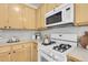 A full kitchen with gas range, stainless steel appliances, bright cabinets, and tile backsplash at 19691 E 59Th Dr, Aurora, CO 80019