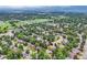 Expansive aerial view of a residential area with tree coverage, green spaces, and mountain views, offering a tranquil setting at 2473 S Carr Ct, Lakewood, CO 80227