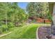 Spacious backyard featuring a lush lawn, mature trees, and a charming garden at 2473 S Carr Ct, Lakewood, CO 80227