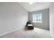 Neutral bedroom featuring new carpet, a comfortable lounge chair, and a bright sunny window at 15700 E Jamison Dr # 305, Englewood, CO 80112