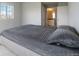 Cozy bedroom with a plush gray quilt, a sunny window, and an ensuite bathroom at 15700 E Jamison Dr # 305, Englewood, CO 80112