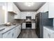 Modern kitchen featuring stainless steel appliances, granite countertops, and white cabinetry at 15700 E Jamison Dr # 305, Englewood, CO 80112