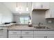 Open kitchen showcasing granite countertops, stainless steel sink, and a view of the living area at 15700 E Jamison Dr # 305, Englewood, CO 80112