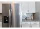 Kitchen featuring stainless steel refrigerator and white cabinets against gray backsplash at 15700 E Jamison Dr # 305, Englewood, CO 80112