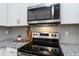 Kitchen details highlighting stainless steel appliances, granite countertops, and stylish backsplash at 15700 E Jamison Dr # 305, Englewood, CO 80112