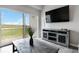 Bright living area featuring a mounted TV, stylish furniture, and sliding glass doors with balcony view at 15700 E Jamison Dr # 305, Englewood, CO 80112