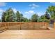 Wooden backyard deck with a wooden railing and views of the property's large trees and backyard at 2711 S Fenton St, Denver, CO 80227