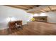 Large basement featuring a brick fireplace, wood-beamed ceiling, and stylish furnishings at 2711 S Fenton St, Denver, CO 80227