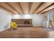 Spacious basement with a brick fireplace, wood-beamed ceiling, and sliding glass door at 2711 S Fenton St, Denver, CO 80227