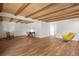Large basement featuring a brick fireplace, wood-beamed ceiling, and laminate floors at 2711 S Fenton St, Denver, CO 80227