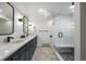 Renovated bathroom with double sinks, granite countertop, and glass-enclosed shower with seat at 2711 S Fenton St, Denver, CO 80227