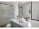 Bathroom featuring a glass shower, decorative mirror, and stylish vanity at 2711 S Fenton St, Denver, CO 80227
