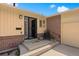 Charming front porch with black security door, 'Hello' mat, and brick accents, leading to the home's entrance at 2711 S Fenton St, Denver, CO 80227