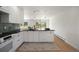 Contemporary kitchen with white cabinetry, stainless appliances, dark countertops, and an open layout at 2711 S Fenton St, Denver, CO 80227