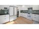 Modern kitchen with white cabinets, stainless steel appliances, dark counters, and hardwood flooring at 2711 S Fenton St, Denver, CO 80227