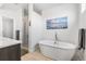 Sleek bathroom with a soaking tub, glass shower, and beach-themed art at 3207 W 25Th Ave, Denver, CO 80211