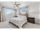 Bright bedroom with a ceiling fan, large windows and a bed with floral bedding at 3207 W 25Th Ave, Denver, CO 80211