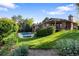 Lush backyard with a pristine pool, manicured lawn, and a charming brick home surrounded by mature trees at 92 S Devinney St, Golden, CO 80401