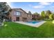 Beautiful backyard featuring swimming pool, patio, brick house, lush greenery, and deck for outdoor entertaining at 92 S Devinney St, Golden, CO 80401