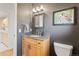 Stylish half bathroom with a granite countertop, wooden cabinets, and modern lighting fixtures at 92 S Devinney St, Golden, CO 80401