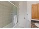 The bathroom has a tiled shower/tub combo with a glass door next to a white door and wood cabinet at 92 S Devinney St, Golden, CO 80401